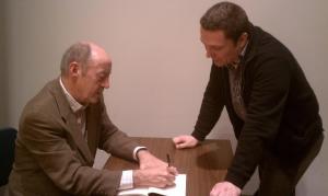 Billy Collins signs his poem for me, right befoe I crack him up. 